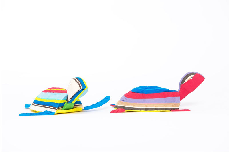 Two hand-carved multicolored turtle sculpture made of upcycled flip flops by Ocean Sole.
