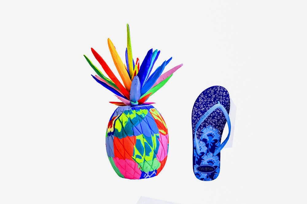 Hand-carved multicolored pineapple sculpture made of upcycled flip flops by Ocean Sole in size comparison to a flip flop.