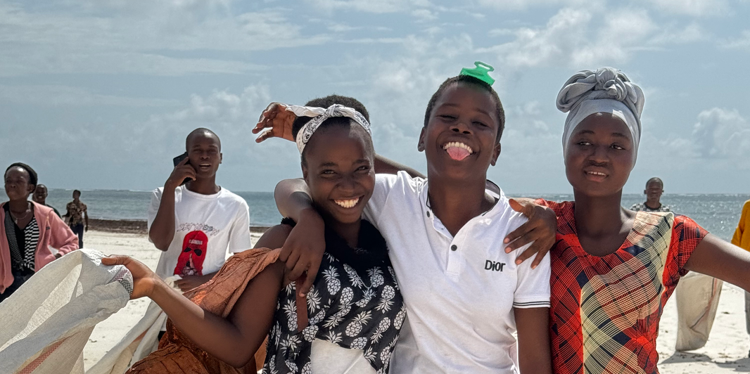 Students participating in the International Coastal Cleanup Day, actively collecting rubbish from the beach to promote marine conservation and environmental awareness.