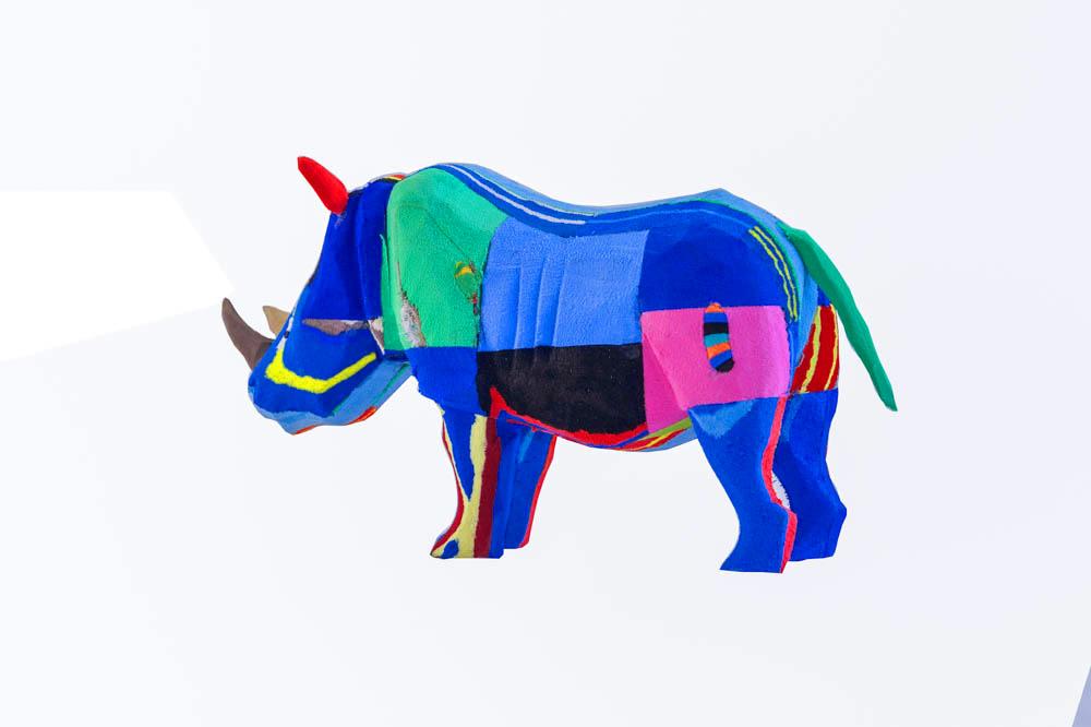 Hand-carved multicolored rhino sculpture made of upcycled flip flops by Ocean Sole.