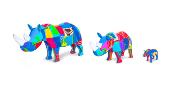 Three hand-carved multicolored rhino sculptures made of upcycled flip flops by Ocean Sole lined up in size comparison.