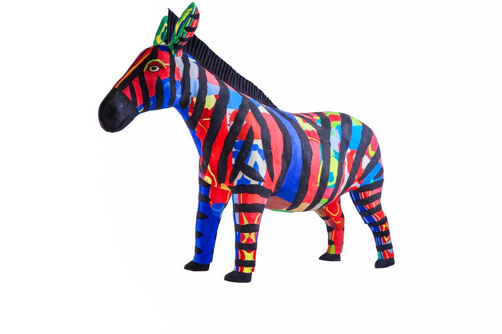 Hand-carved multicolored zebra sculpture made of upcycled flip flops by Ocean Sole.