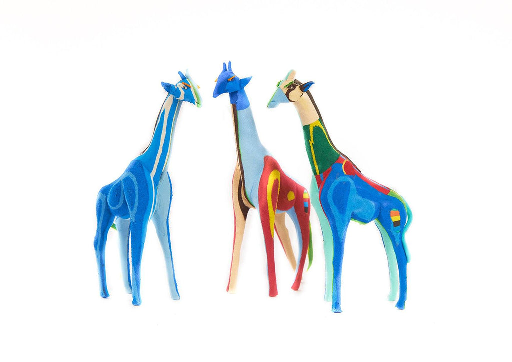 Three small hand-carved multicolored giraffe sculptures made of upcycled flip flops by Ocean Sole.