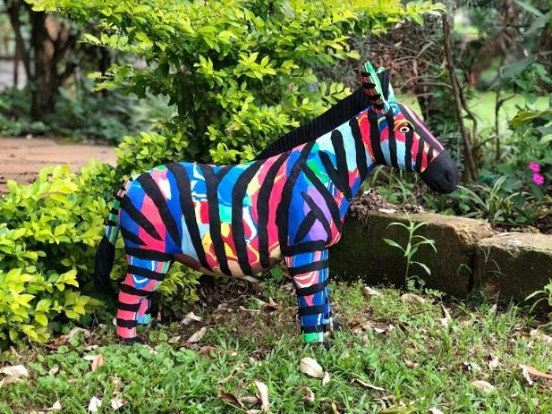Hand-carved multicolored zebra sculpture made of upcycled flip flops by Ocean Sole.