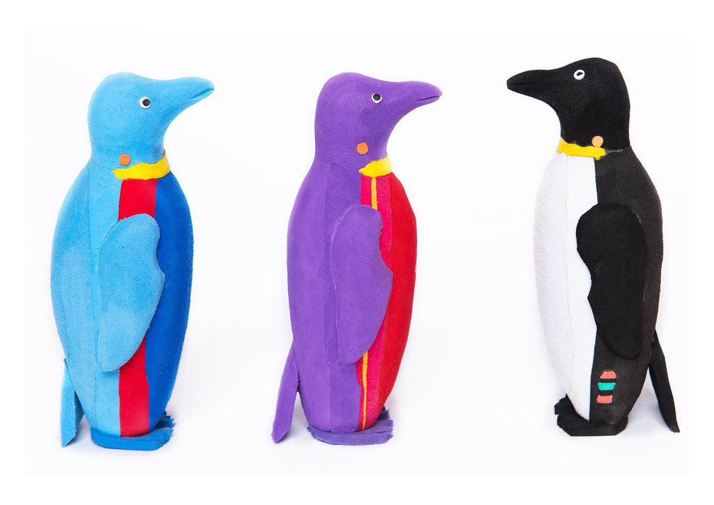 Three hand-carved multicolored penguin sculpture made of upcycled flip flops by Ocean Sole.