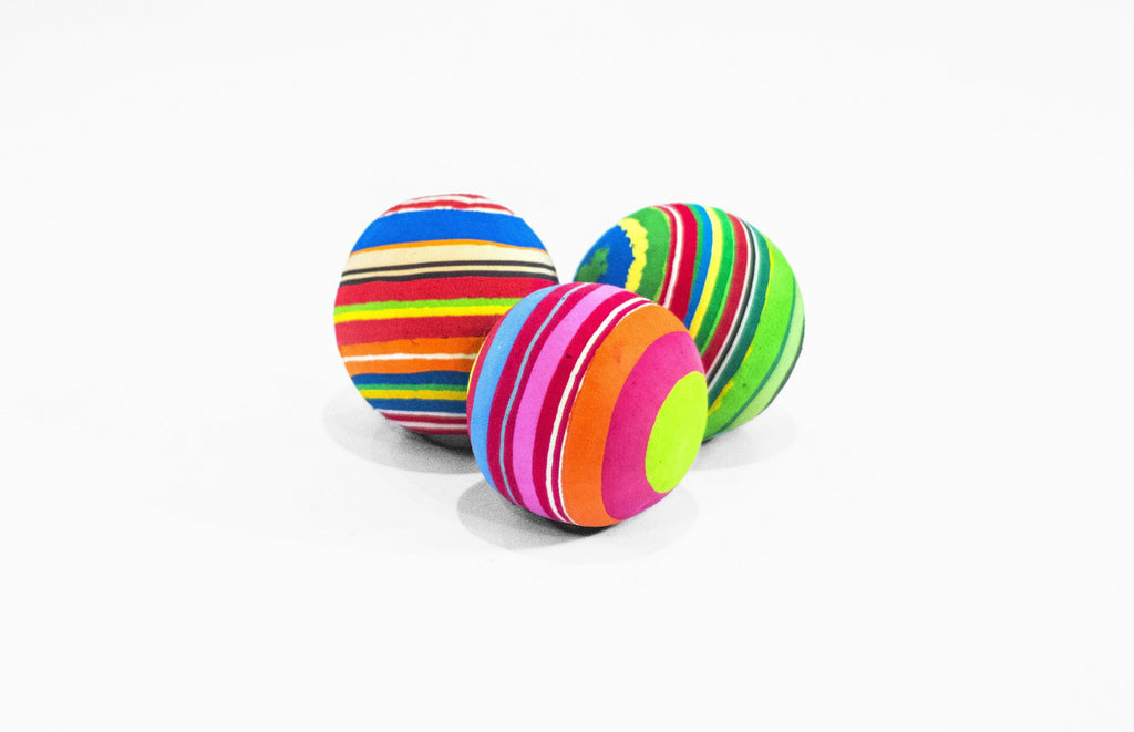 Set of 3 hand-carved multicolored juggling balls made of upcycled flip flops by Ocean Sole.