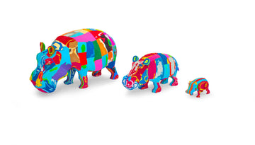 Three hand-carved multicolored hippo sculptures made of upcycled flip flops by Ocean Sole lined up in size comparison.
