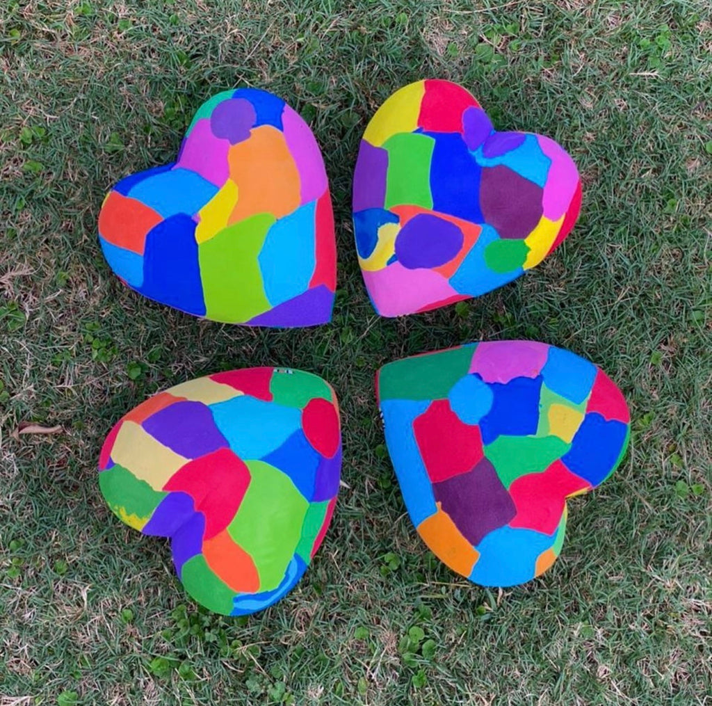 Four hand-carved multicolored heart sculpture made of upcycled flip flops by Ocean Sole.