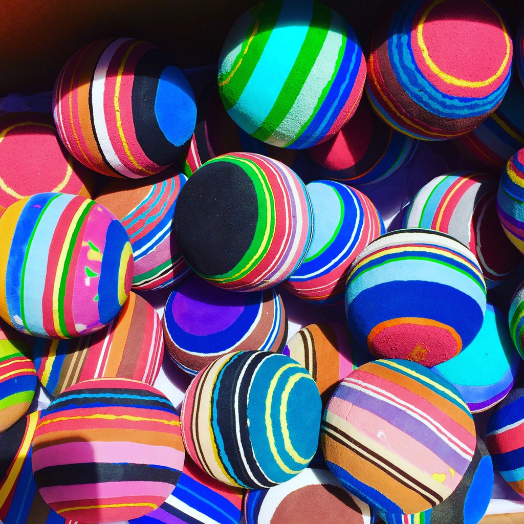 Group of hand-carved multicolored juggling balls made of upcycled flip flops by Ocean Sole.