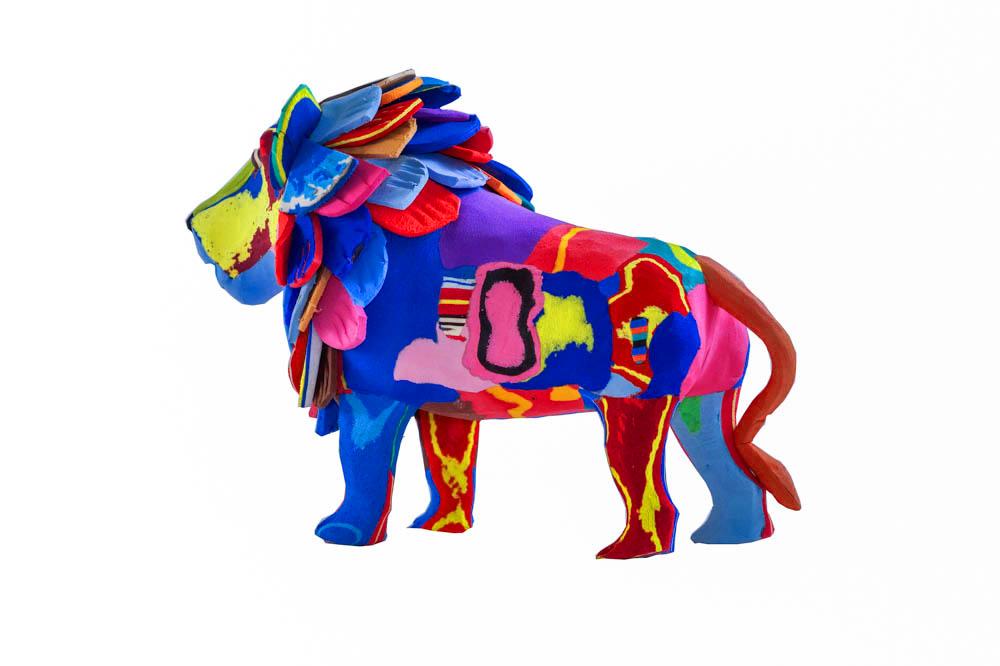 Hand-carved multicolored standing lion sculpture made of upcycled flip flops by Ocean Sole.