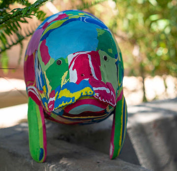 Large hand-carved multicolored manatee sculpture made of upcycled flip flops by Ocean Sole.