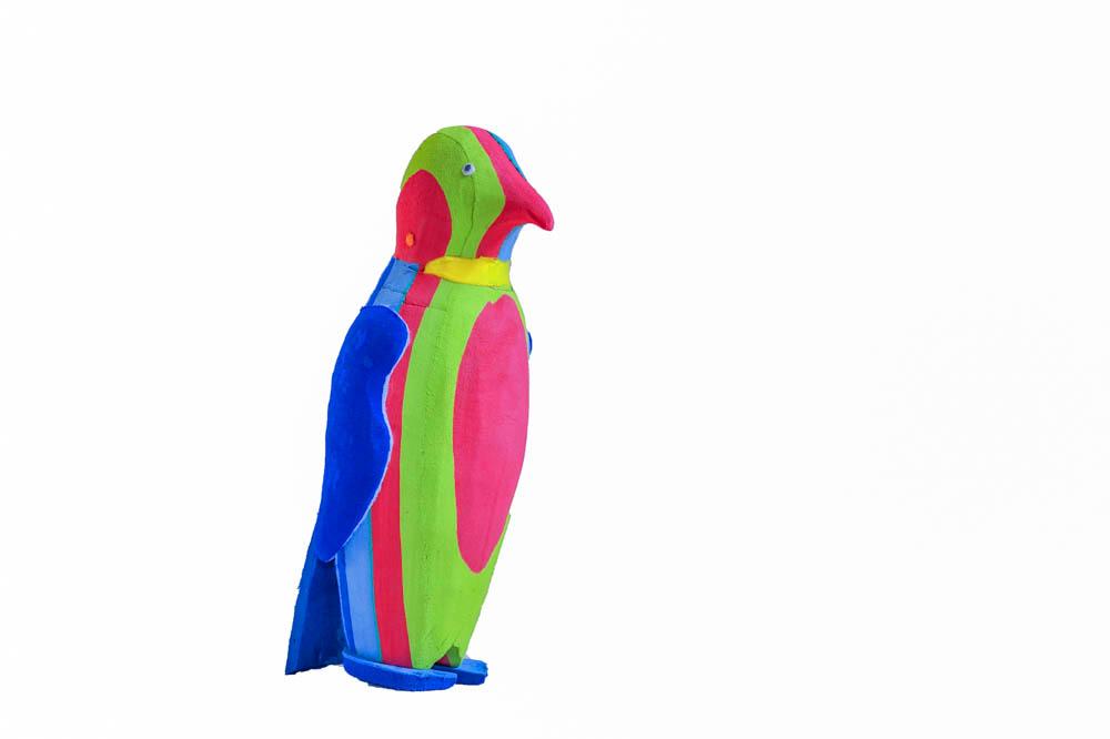 Hand-carved multicolored penguin sculpture made of upcycled flip flops by Ocean Sole.