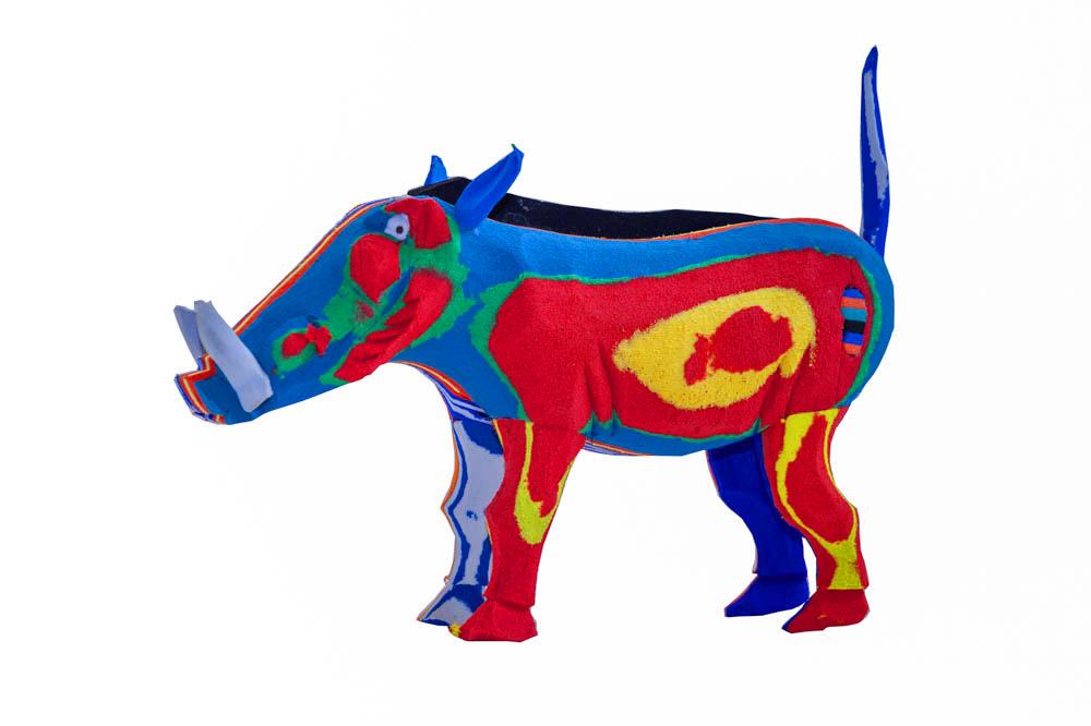 Hand-carved multicolored warthog sculpture made of upcycled flip flops by Ocean Sole.