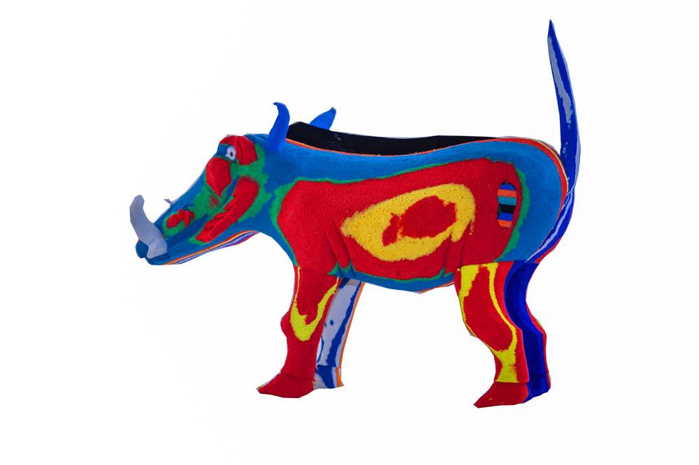 Hand-carved multicolored warthog sculpture made of upcycled flip flops by Ocean Sole.