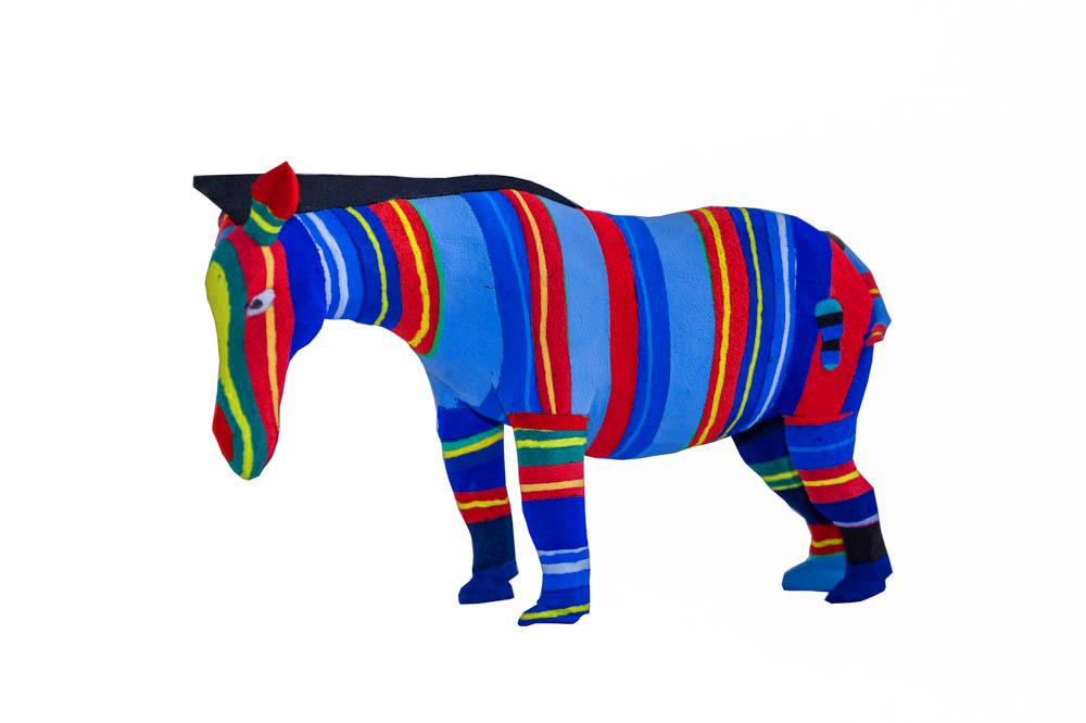 Hand-carved multicolored zebra sculpture made of upcycled flip flops by Ocean Sole.