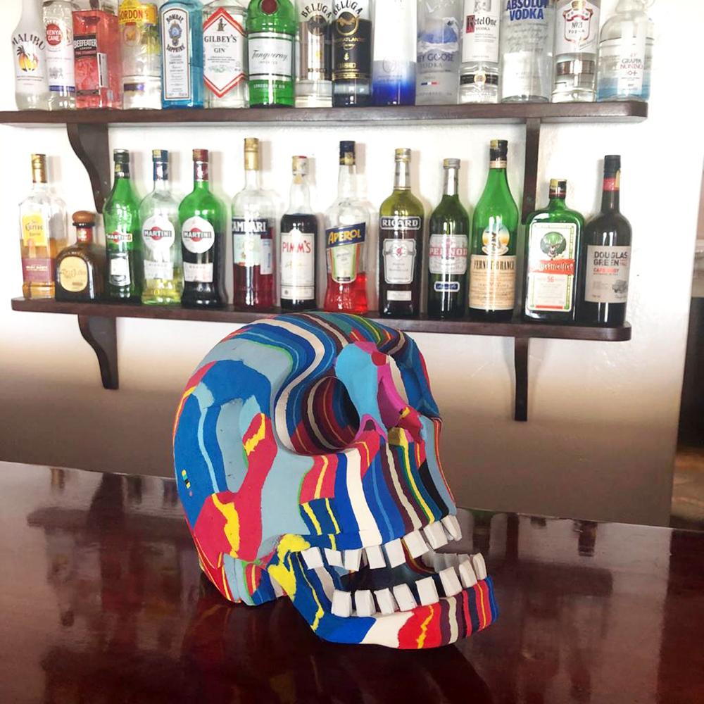 Hand-carved multicolored skull sculpture made of upcycled flip flops by Ocean Sole.