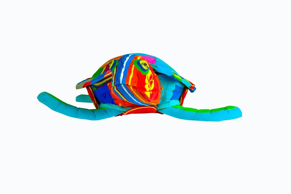 Hand-carved multicolored turtle sculpture made of upcycled flip flops by Ocean Sole.