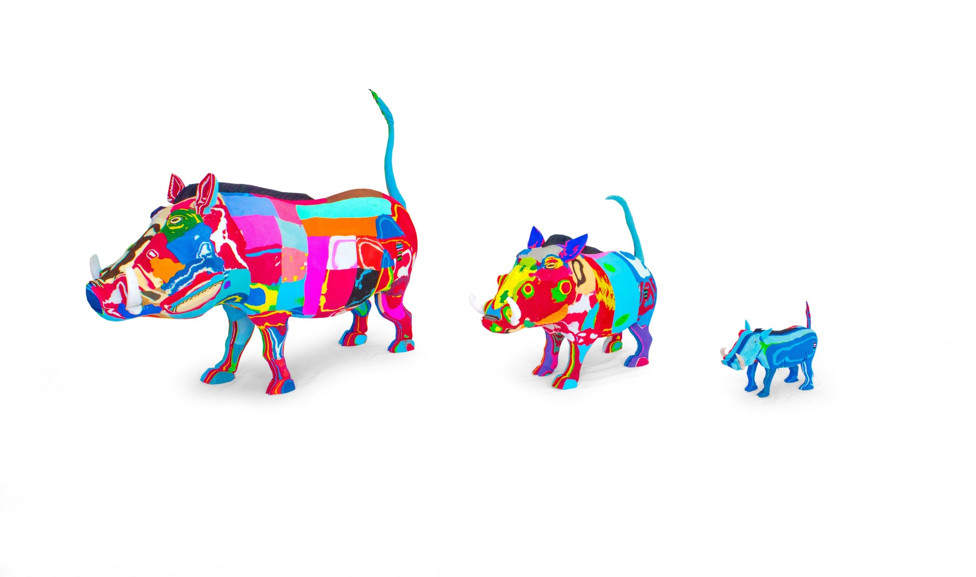 Three hand-carved multicolored warthog sculptures made of upcycled flip flops by Ocean Sole lined up in size comparison.