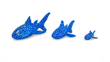 Three hand-carved multicolored whale shark sculptures made of upcycled flip flops by Ocean Sole lined up in size comparison.