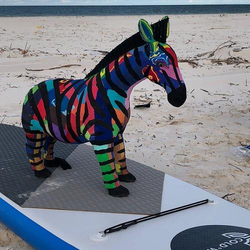 Hand-carved multicolored zebra sculpture made of upcycled flip flops by Ocean Sole.
