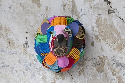 Hand-carved multicolored lion wall art sculpture made of upcycled flip flops by Ocean Sole designed to hang on your wall.