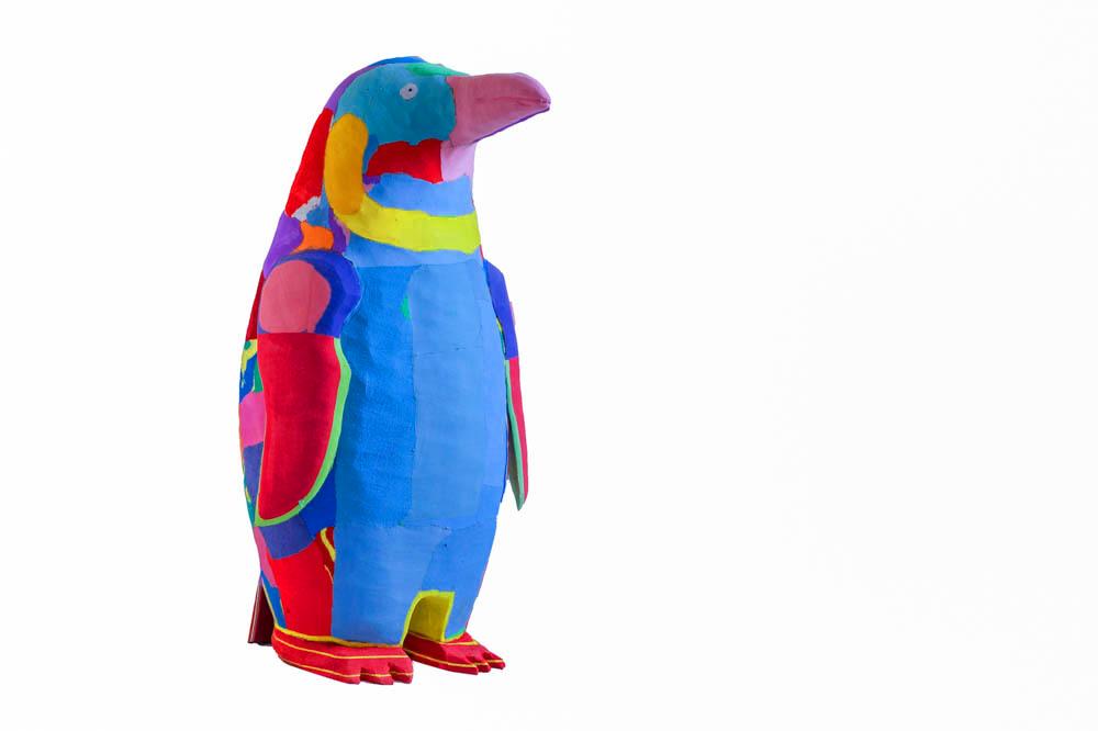 Hand-carved multicolored penguin sculpture made of upcycled flip flops by Ocean Sole.