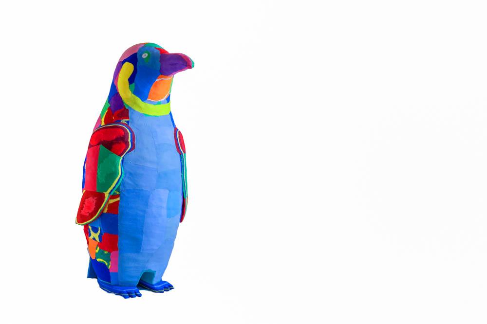 Hand-carved multicolored penguin sculpture made of upcycled flip flops by Ocean Sole.