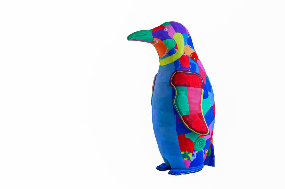 Hand-carved multicolored penguin sculpture made of upcycled flip flops by Ocean Sole.