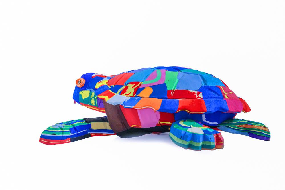 Large hand-carved multicolored turtle sculpture made of upcycled flip flops by Ocean Sole.