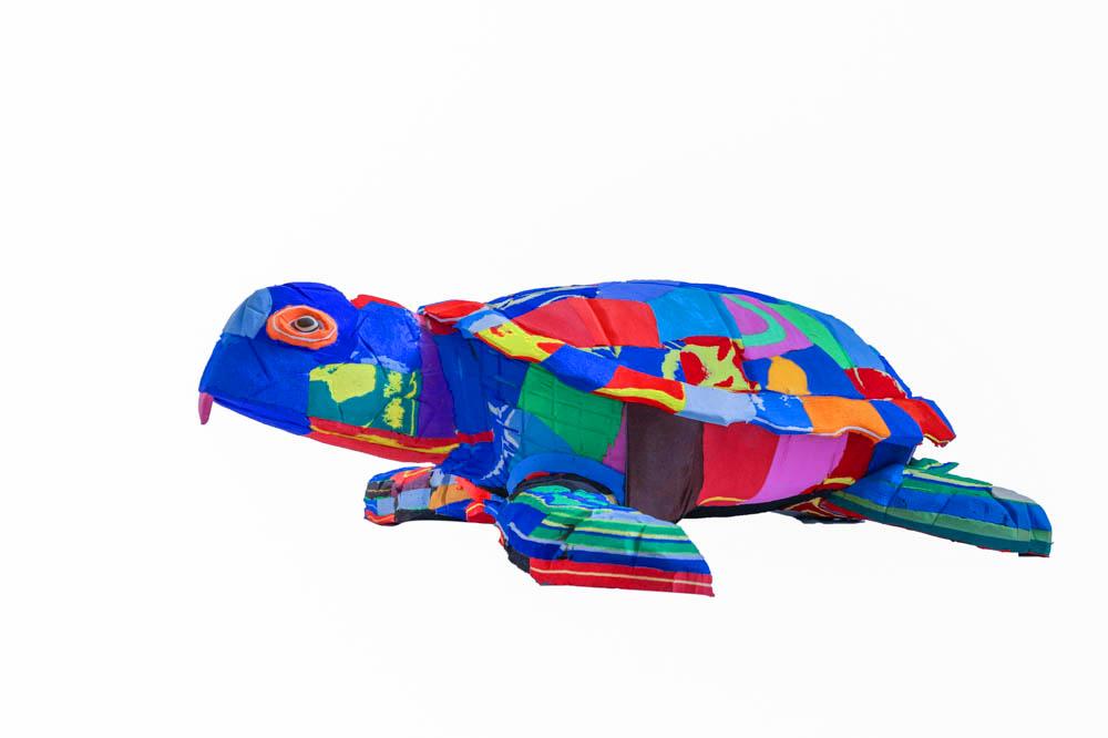 Large hand-carved multicolored turtle sculpture made of upcycled flip flops by Ocean Sole.