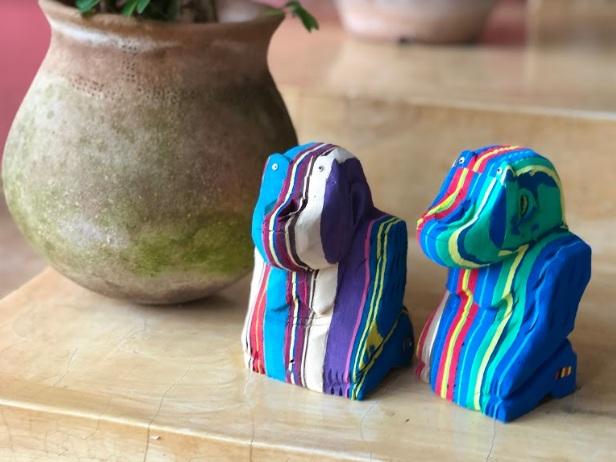 Two hand-carved multicolored sitting gorilla sculpture made of upcycled flip flops by Ocean Sole.