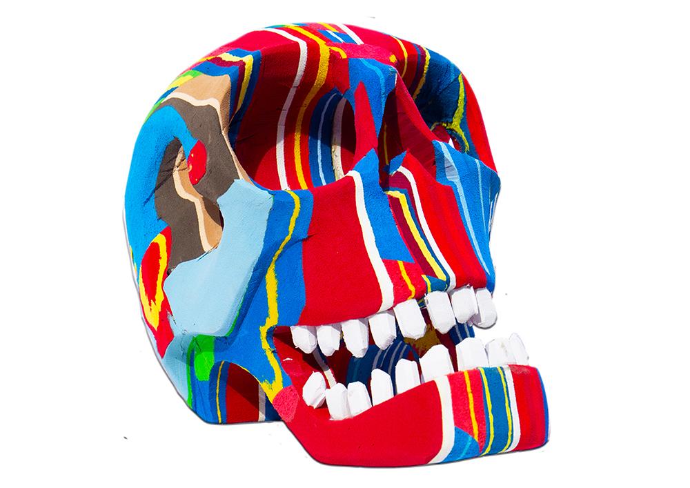 Hand-carved multicolored skull sculpture made of upcycled flip flops by Ocean Sole.
