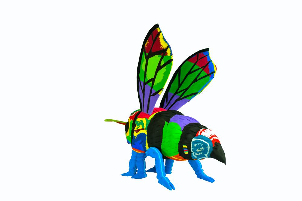 Hand-carved multicolored bee sculpture made of upcycled flip flops by Ocean Sole.