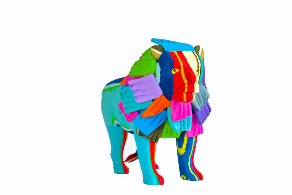 Hand-carved multicolored standing lion sculpture made of upcycled flip flops by Ocean Sole.