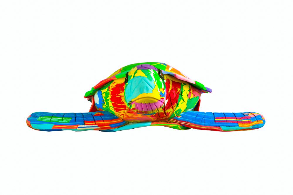 Large hand-carved multicolored turtle sculpture made of upcycled flip flops by Ocean Sole.